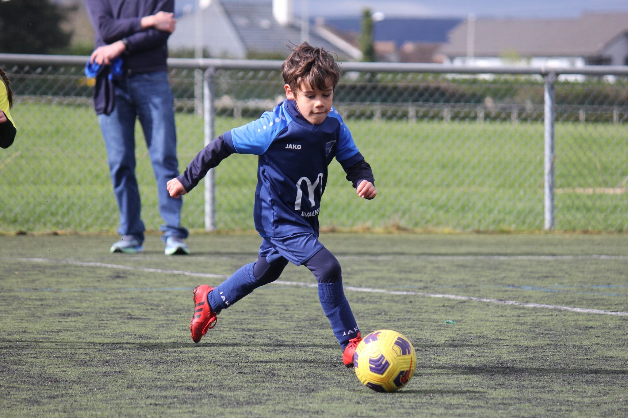 Jeune joueur de l’AFCO conduisant son ballon